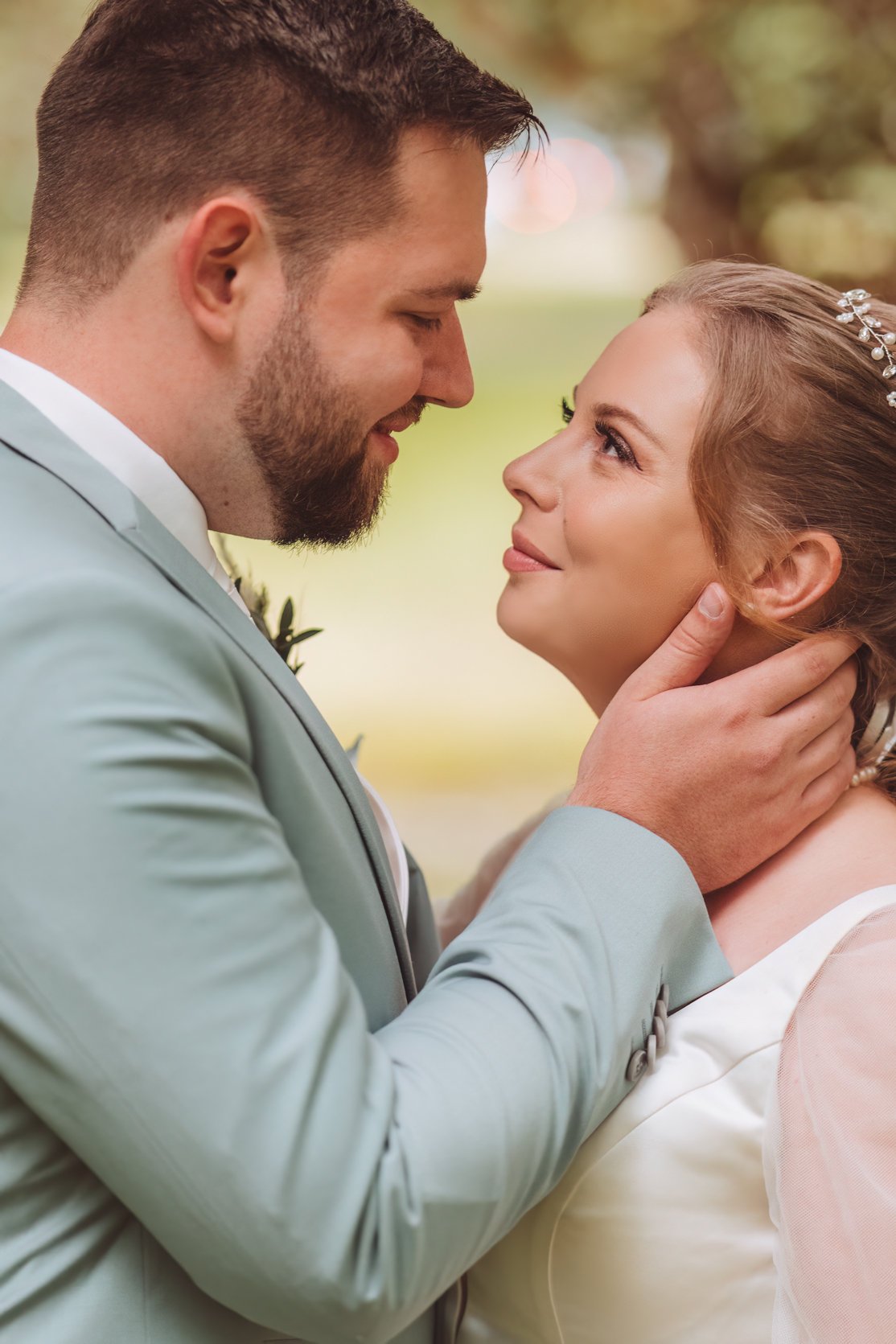 Glückliches Pärchen schaut sich verliebt in die Augen im Celler Schlossgarten - Hochzeitsfotografie