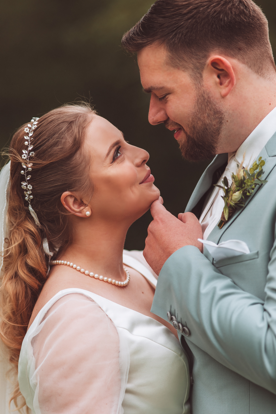 Glückliches Pärchen schaut sich verliebt in die Augen im Celler Schlossgarten - Hochzeitsfotografie